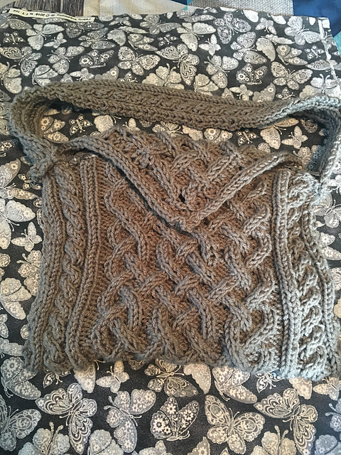 A knitted purse featuring celtic cables of various designs.