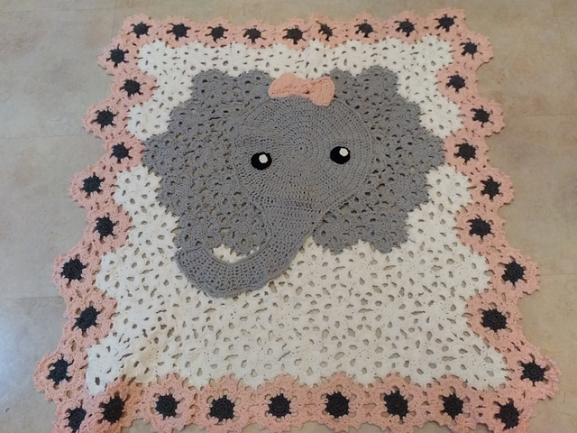 A crocheted baby blanket made of hexagon motifs. The colors used form the head of a elephant.